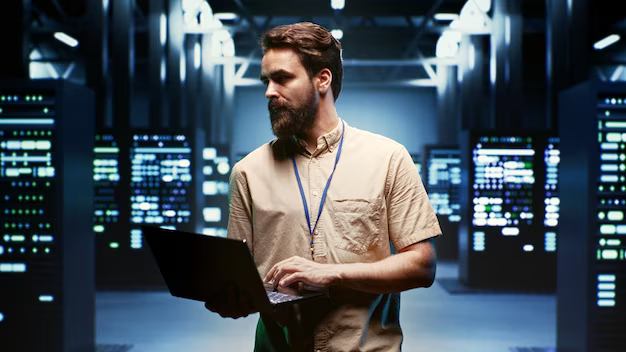 Man with computer among servers